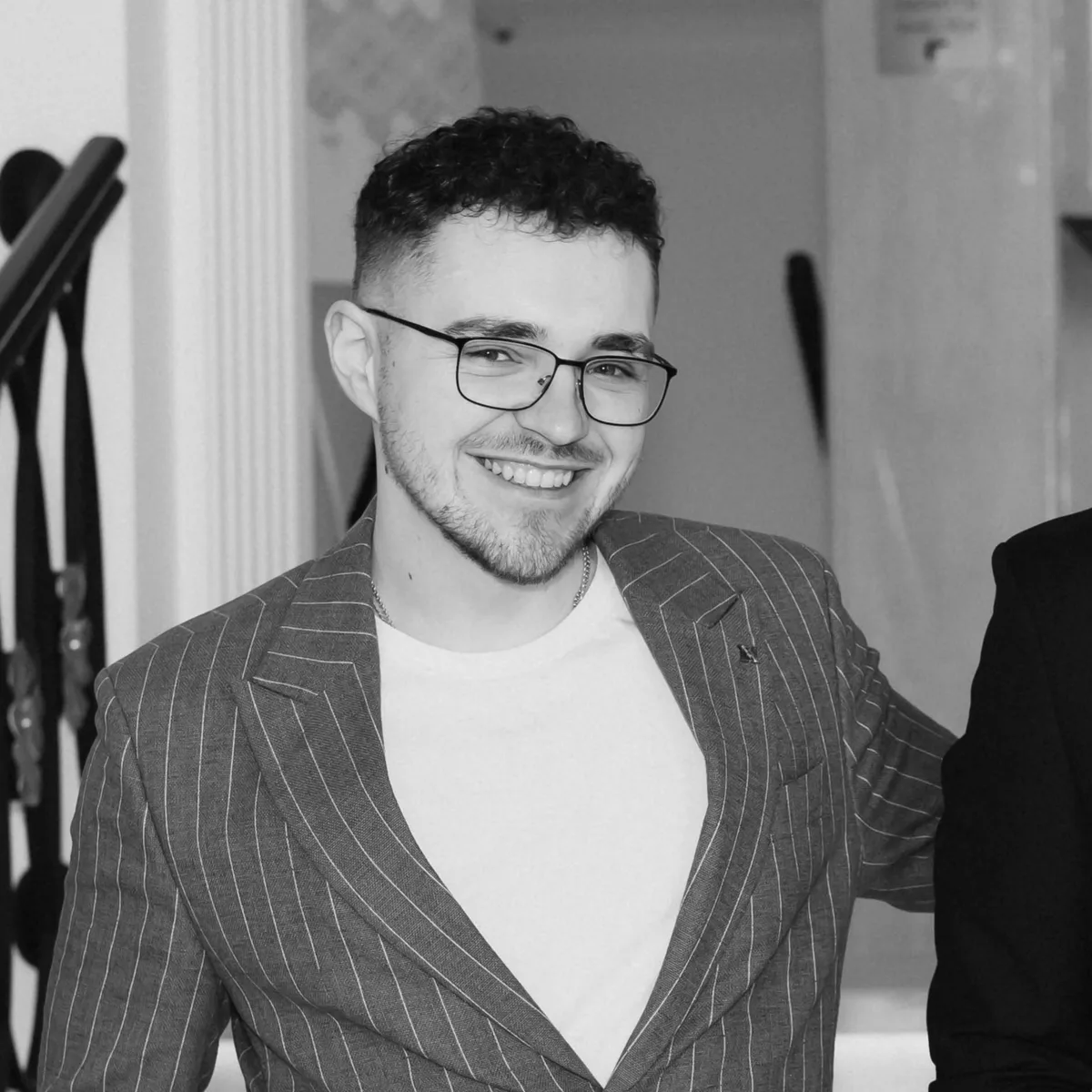 Liubomyr Manastyretskyi, smiling, in glasses and a pinstripe blazer